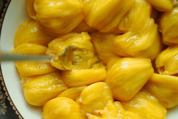 Obraz premium Tasting fresh jackfruit in a kitchen setting