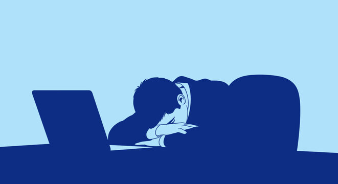 Exhausted businessman sleeping on his desk in front of a laptop computer.