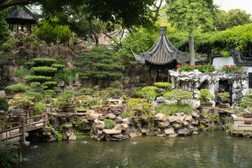 Naklejka premium traditional garden displays chinese landscape with pavilion and rockery. beautiful garden features curved roof and green vegetation. historic garden represents harmony between nature and architecture