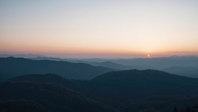 Sunrise over rolling mountains in the distance