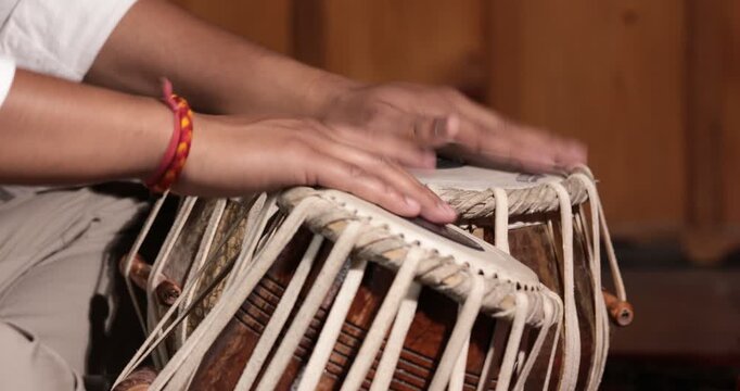 A man's hands playing the tabla, a indian classical musical instrument
