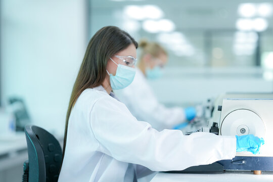 Histopathology technician operating microtome for tissue biopsy sectioning. Biological researcher preparing histological specimen slides in sterile pathology lab.