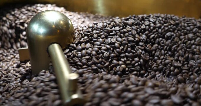 Roasting process in coffee roasting machine,Natural roast coffee beans mixing,mixing machine mixes roasted coffee beans in roaster, close up