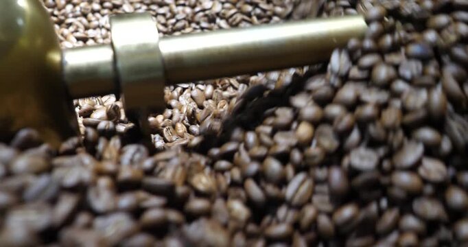 Roasting process in coffee roasting machine,Natural roast coffee beans mixing,mixing machine mixes roasted coffee beans in roaster, close up