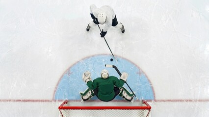 Naklejka premium Ice hockey player attacking goal against goalkeeper from overhead view. Concept of professional hockey competition, goal scoring and tactical sports performance.