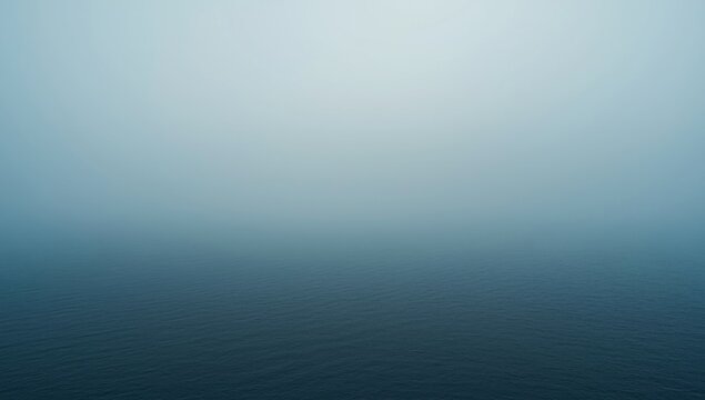 Foggy ocean surface under a pale sky