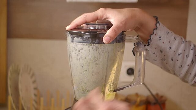 Making smoothie in blender at home in kitchen