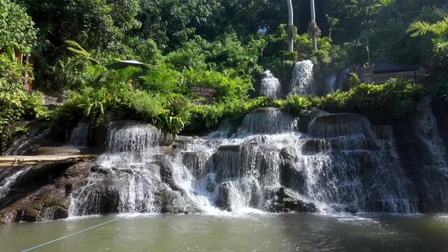 Poh gadang waterfall in Ubud, Bali. Cascades of water flow in the sunshine. In the heart of the jungle, static shot.