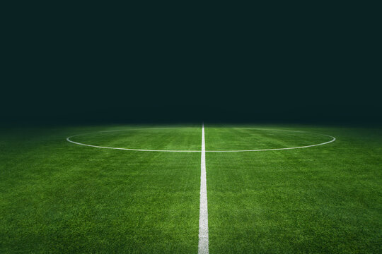 Dramatic illuminated center circle on soccer field under dark night sky with stadium lights stadium pitch field lighting grass turf arena ground sporting even
