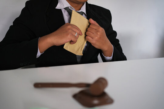 Dishonest businessman puts envelope, US dollars, into his coat pocket in the dark - the concept of corruption and embezzlement and bribery.
