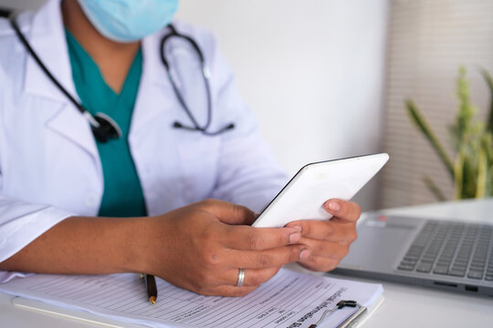 An Asian female doctor or pharmacist holds a medicine bottle and a smartphone tablet. Doctors providing online medication consultations.
