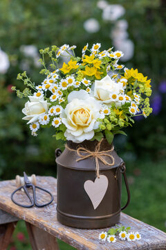 Blumenstrau&szlig; mit wei&szlig;en Rosen, Frauenmantel, Mutterkraut und Goldfelberich im vintage Milchkrug