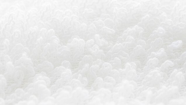 Extreme macro photograph of soft fluffy pure white terrycloth towel texture showing intricate interwoven cotton fiber loops in selective focus.