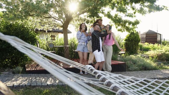 Friends having fun together during a relaxing time in a lush green garden. Concept summer, happiness and outdoor gathering.
