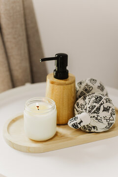 Still life of luxury spa essentials. A bottle with a massage oil and candle on a table.