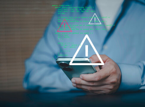 Mobile cybersecurity threat concept with warning alert and code overlay, data breach risk, malware detection, hacking attempt, information security, digital protection and cyber attack prevention.