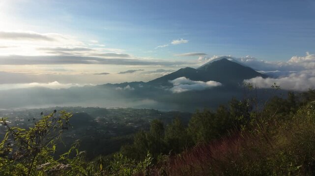 Mount Batur peak looking out at Mount Abang, Agung, lake batur at sunrise. Bali. Slow motion track / dolly across. Epic scenery. Clouds on the horizon, beautiful peaks. 