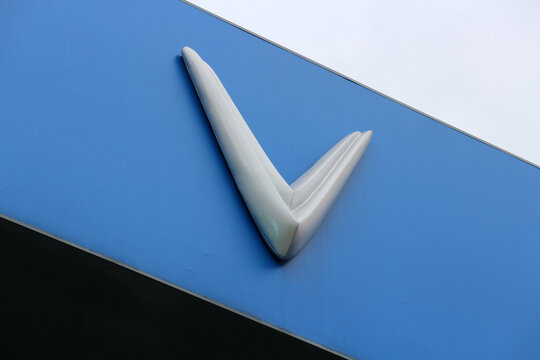 DANANG, VIETNAM - JANUARY 22, 2026: A close-up view of the VinFast corporate V logo sign displayed on a blue background.