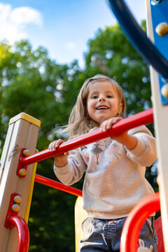 Cute beautiful smiling little girl on the playground for fun, games or recreation. Face and happy with adorable kid outdoor for development, growth or recess in summer.