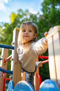 Cute beautiful smiling little girl on the playground for fun, games or recreation. Face and happy with adorable kid outdoor for development, growth or recess in summer.