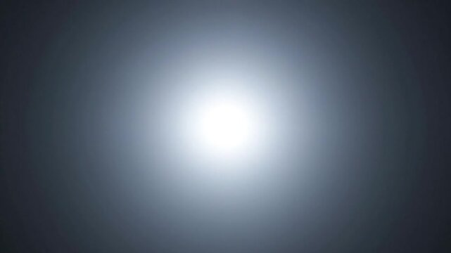 A bright glowing light source centered on a dark background