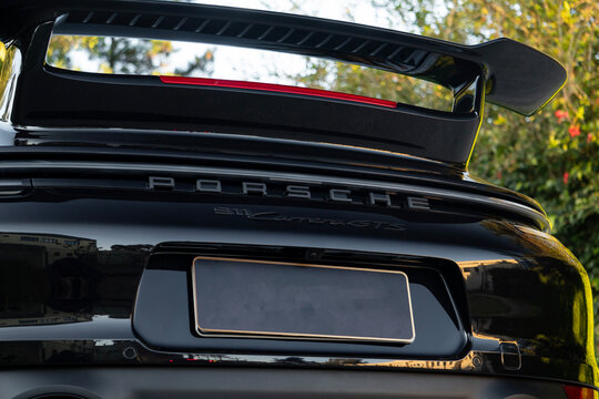 Black Porsche 911 Carrera GTS rear badge close up, Luxury sports car spoiler detail outdoors