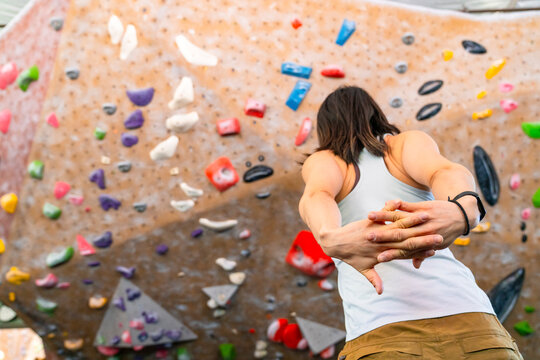 rock climber stretching arms preparing bouldering gym 
