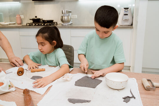 Kids have fun playing with clay in the kitchen making different shapes