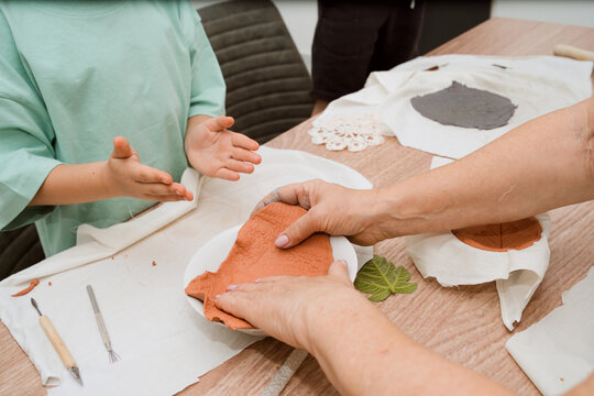 Multigenerational Family Spending Time Together Making Clay Plate