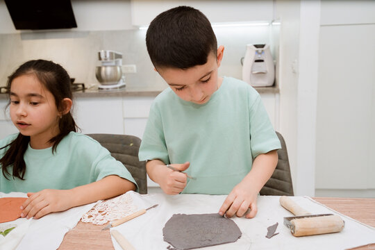 Siblings Making Clay Art at Home Creating Textured Clay Surface  