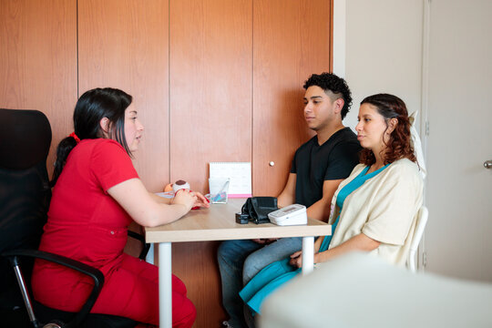 Midwife consulting with young pregnant couple