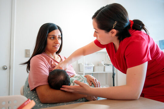 Midwife helping mother with breastfeeding