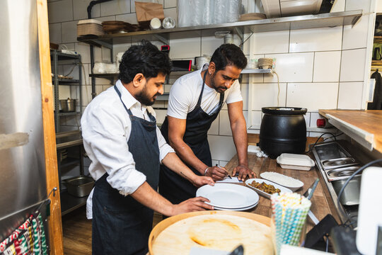 Staff preparing food order at restaurant counter