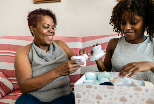 African american women opening baby shower gifts