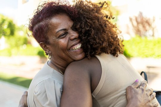 African american women embracing, sharing happy family bond