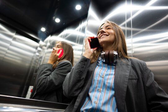 Woman talking on phone in elevator during day