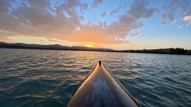 Immersive POV from a kayak - paddling on Boedecker Reservoir in Loveland, Colorado, with sunset over Rocky Mountains