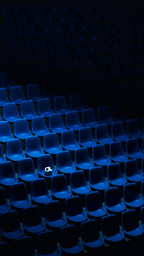 Soccer ball rests on blue stadium seats in an empty arena