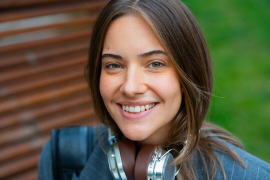 A woman stands outside with a smile