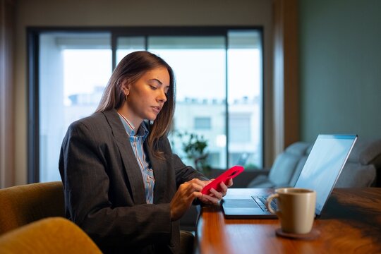 Woman uses phone while sitting at desk
