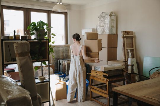 Woman packing and organizing cardboard boxes for a house move