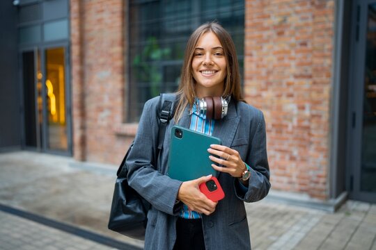 Smiling woman with tablet in city