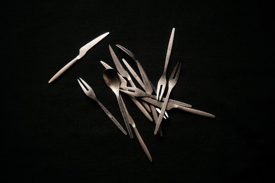 Minimal cutlery composition on a dark background
