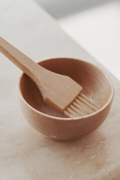 Wooden hair colour brush in a wooden bowl
