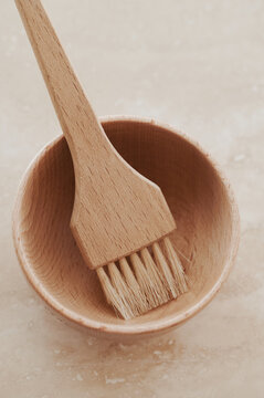 Wooden hair colour brush in a wooden bowl