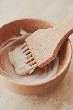 Wooden hair colour brush in a wooden bowl