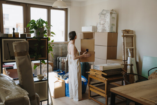 Woman packing and organizing cardboard boxes for a house move