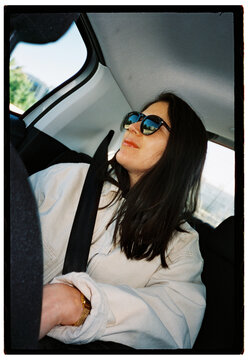 Young woman wearing sunglasses inside a car
