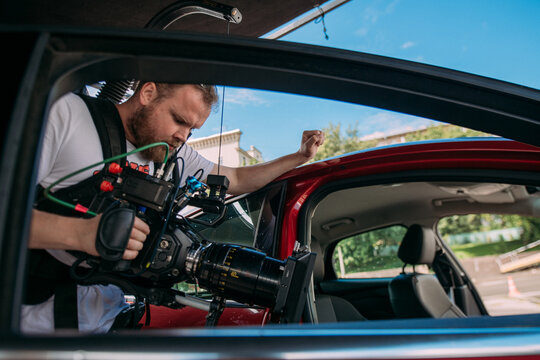 The director of photography with a camera on the set. A professional videographer is working on filming a movie or commercial for a TV series. The filming process takes place indoors in a studio.