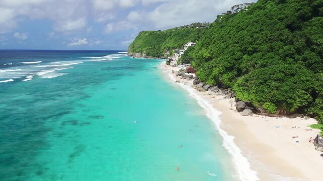 Tropical landscape with cliffs on coastline and luxury beach with ocean and waves in Bali. Drone view